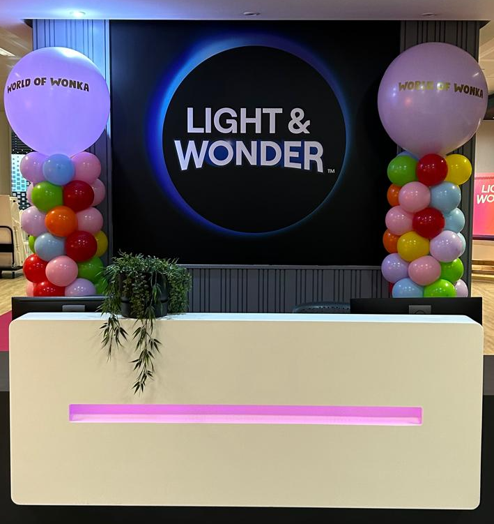 Candy-coloured balloon towers with branded toppers created for Light & Wonder’s World of Wonka activation, adding bold visual impact to their reception space.
