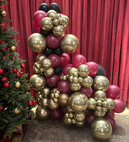 A rich, festive balloon display in gold and burgundy — the perfect luxe touch for Christmas event styling.
